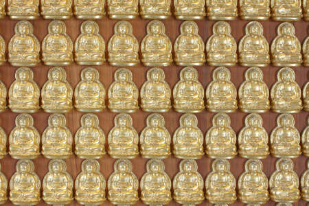 pattern of gold buddha doll on the hard wood.の写真素材