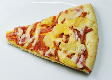 Hawaiian Pizza piece with close up on white Dishの写真素材