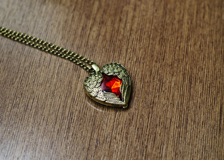 Pendant vitage heart shape on wooden backgroundの写真素材