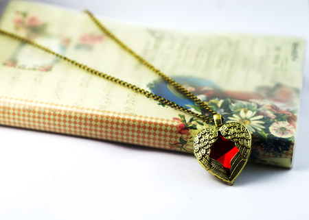 Close up of Pendant necklace vintage heart-shape and bookの写真素材