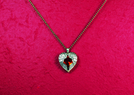 Pendant vintage with Red heart shape on Red backgroundの写真素材