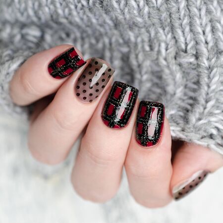 Burgundy manicure with a Scottish cage and dots patternの写真素材