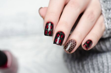 Burgundy manicure with a Scottish cage and dots pattern