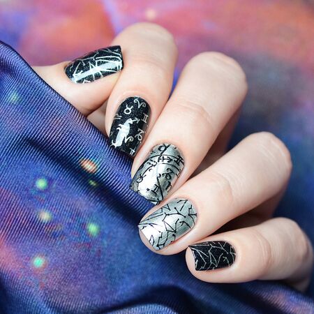 black and gray manicure with a constellation map pattern on a cosmic backgroundの写真素材