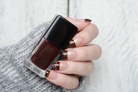 Bordeaux french manicure with gold flakes with gray sweaterの写真素材