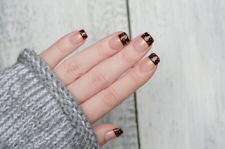Bordeaux french manicure with gold flakes with gray sweaterの写真素材