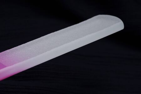 glass nail file for manicure and cuticle on black background
