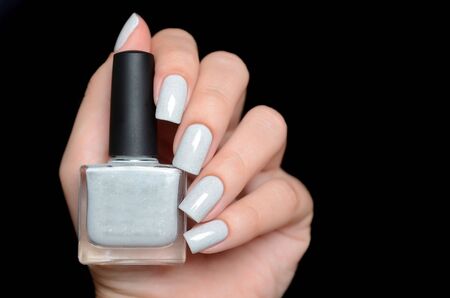 grey shimmer manicure on a black backgroundの写真素材