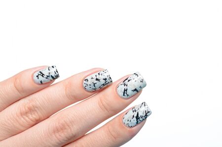 grey shimmer manicure with marblre effect on a white backgroundの写真素材