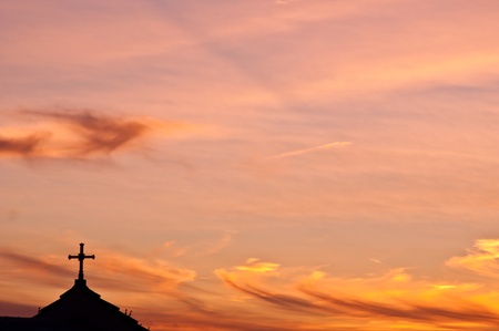 A golden sunset in the Bay of Gibraltar with a church rooftop.の写真素材