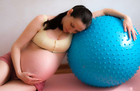 A pregnant woman goes in for sports with a fitness and yoga ball. Concept food, healthy lifestyle.の写真素材
