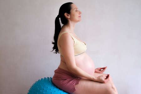 A pregnant woman goes in for sports with a fitness and yoga ball. Concept food, healthy lifestyle.の写真素材