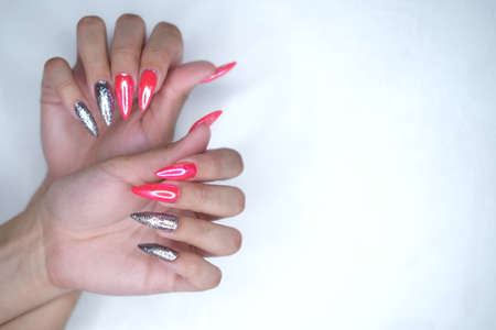 Female hands with extended colored nails close-up.