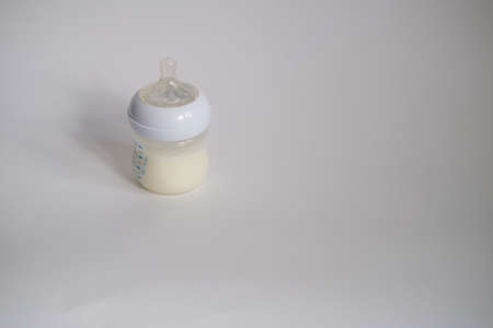 The electric breast pump is on the table in the kitchen. Breast pump with milk. Give expressed breast milk. Breast care for a young motherの写真素材