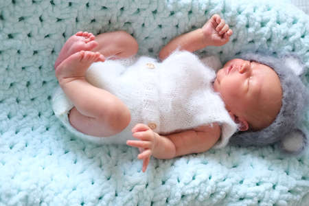 first photo session. newborn child. the child is lying on a blue background in a mouse cap.symbol of the year,の写真素材