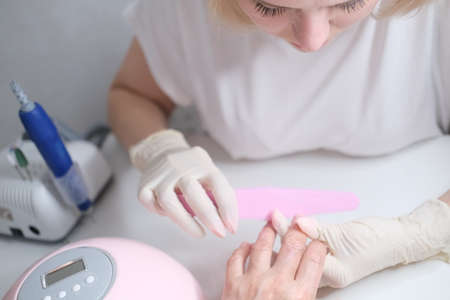 Nail care. Manicure in the salon. The master manicures the girl. Manicure process.の写真素材
