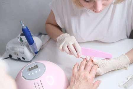 Nail care. Manicure in the salon. The master manicures the girl. Manicure process.の写真素材