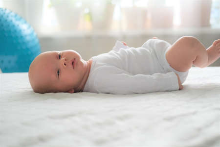 A newborn baby lies on a white blanket. Close-up portrait of a child.の写真素材