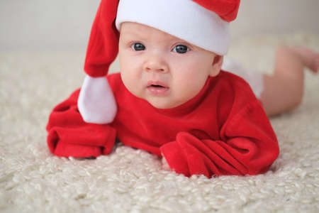 baby in santa costume on white background.Crawling baby in Santa Claus costumeの写真素材