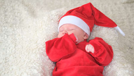 baby in santa costume on white background.Christmas toddler in Santa hat.Baby in red costume and hat.の写真素材