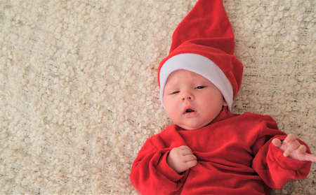 baby in santa costume on white background.Christmas toddler in Santa hatの写真素材