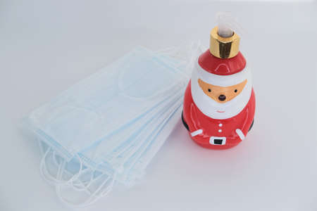 Gift - antibacterial soap Santa Claus and protective masks lie on a white background.の写真素材