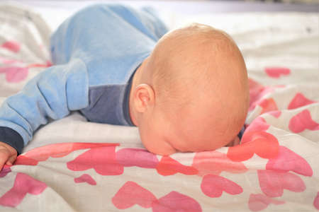 Portrait of a cute 3 month old baby, isolated on white background with red and bright pink hearts.の写真素材