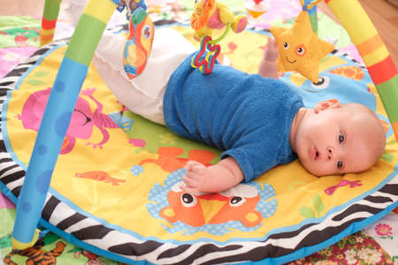 Newborn baby playing Portrait of a cute 3 month old baby lying on a bright blanket.の写真素材