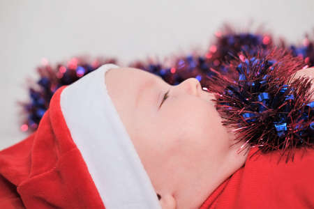 Christmas, winter, new year concept. Portrait of a handsome boy in a hat of Santa Clausの写真素材