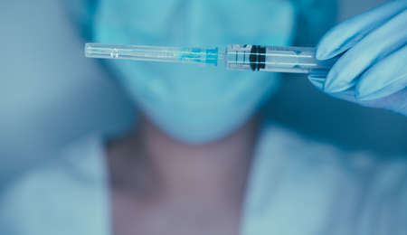 Female hands in gloves hold  vaccine and syringe for injection.   concept, pandemic, vaccination.