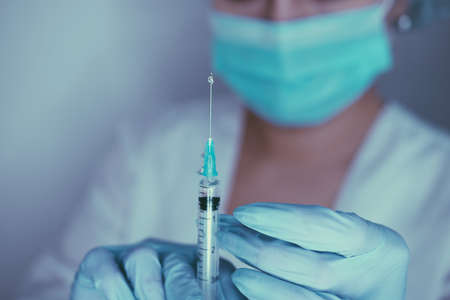 Female hands in gloves hold  vaccine and syringe for injection.   concept, pandemic, vaccination.の写真素材