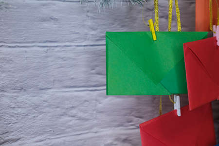 Advent calendar on a background of a brick wall. Multicolored envelopes made by hand
