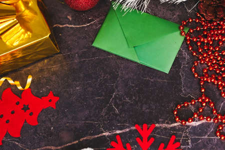 New Year and Christmas gifts. Selective focus. Santa claus hat, boxes with gifts, beads, Christmas toys on a dark background.の写真素材