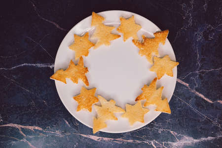 Bread toast in the shape of a Christmas tree and stars lie on a white plate, close-up. Selective focusの写真素材