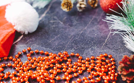 New Year and Christmas gifts. Selective focus. Santa claus hat, boxes with gifts, beads, Christmas toys on a dark backgroundの写真素材