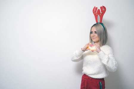 Portrait of a beautiful girl on a light background. The concept of Christmas and New Yearの写真素材