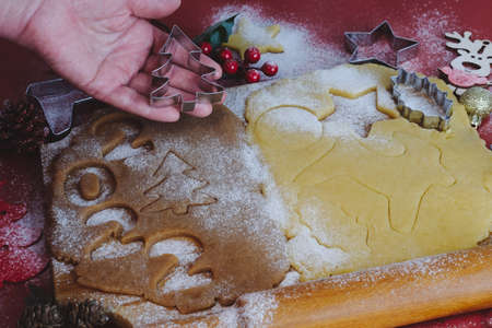Dough for making New Year's and Christmas cookies.Female hands on the background of a wooden board with cookie doughの写真素材