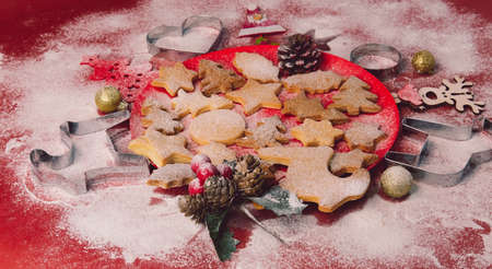 Tasty homemade Christmas cookies, closeup. Gingerbread cookies on a red background. Selective focus.の写真素材