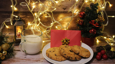 Milk with Christmas cookies for santa claus on a wooden table, selective focus.の写真素材
