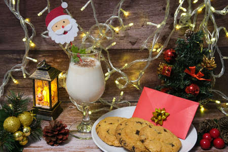 Milk with Christmas cookies for santa claus on a wooden table, selective focus.の写真素材