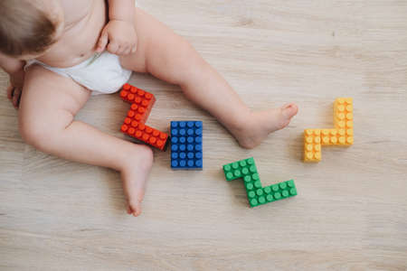 Child plays colorful constructor.Kid collects numbers 2022. Concept - children's toys and childhoodの写真素材