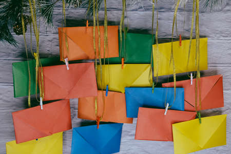 Advent calendar on a background of a brick wall. Multicolored envelopes made by handの写真素材