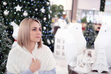 Portrait of a girl with blond hair on the background of a Christmas tree. Selective focusの写真素材