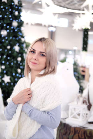 Portrait of a girl with blond hair on the background of a Christmas tree. Selective focusの写真素材