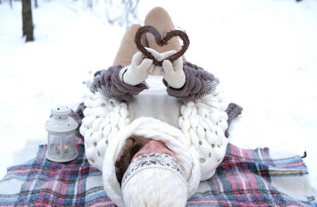 Portrait of a girl holding a handmade wooden Christmas decoration in the shape of a heartの写真素材