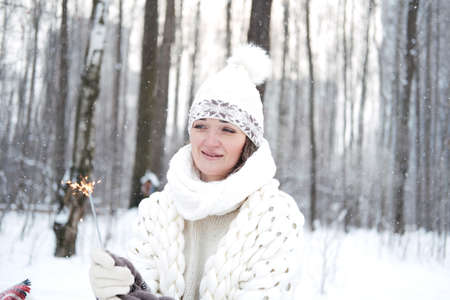 Portrait of a girl holding a burning sparkler candle in her handsの写真素材