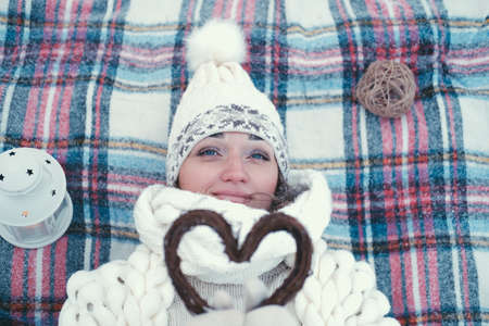 Portrait of a girl holding a handmade wooden Christmas decoration in the shape of a heartの写真素材