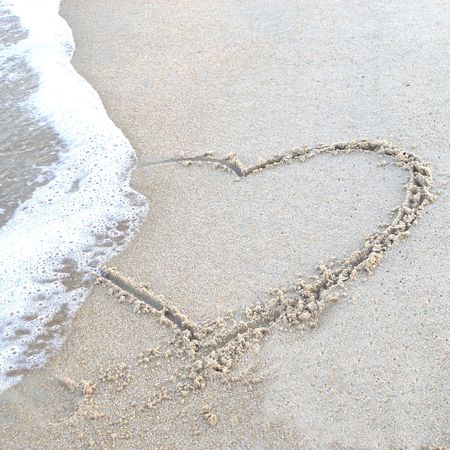 Heart drawn in the sand at the beach.の写真素材
