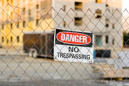 Warning Sign on a Fence Around a Construction Siteの写真素材