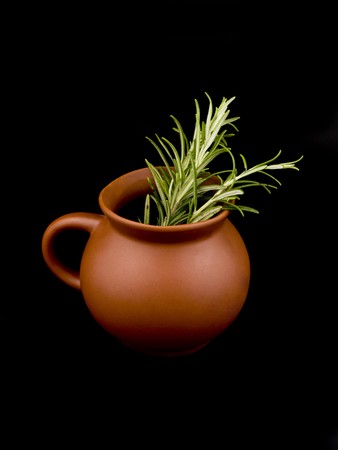 Ceramic cup and fresh rosemary on black backgroundの写真素材
